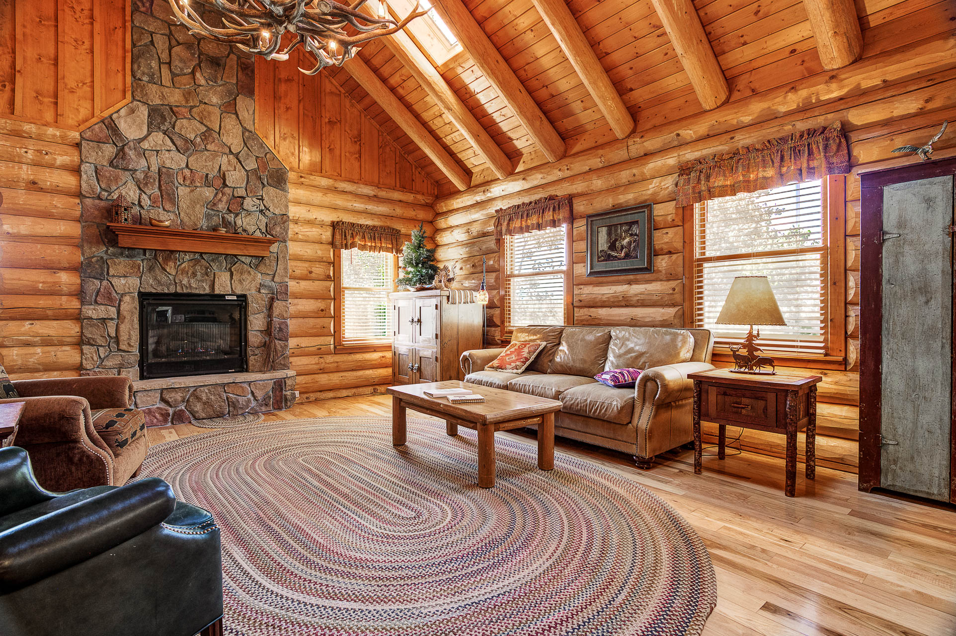 Cabin interior with vaulted pine ceilings and a stone fireplace
