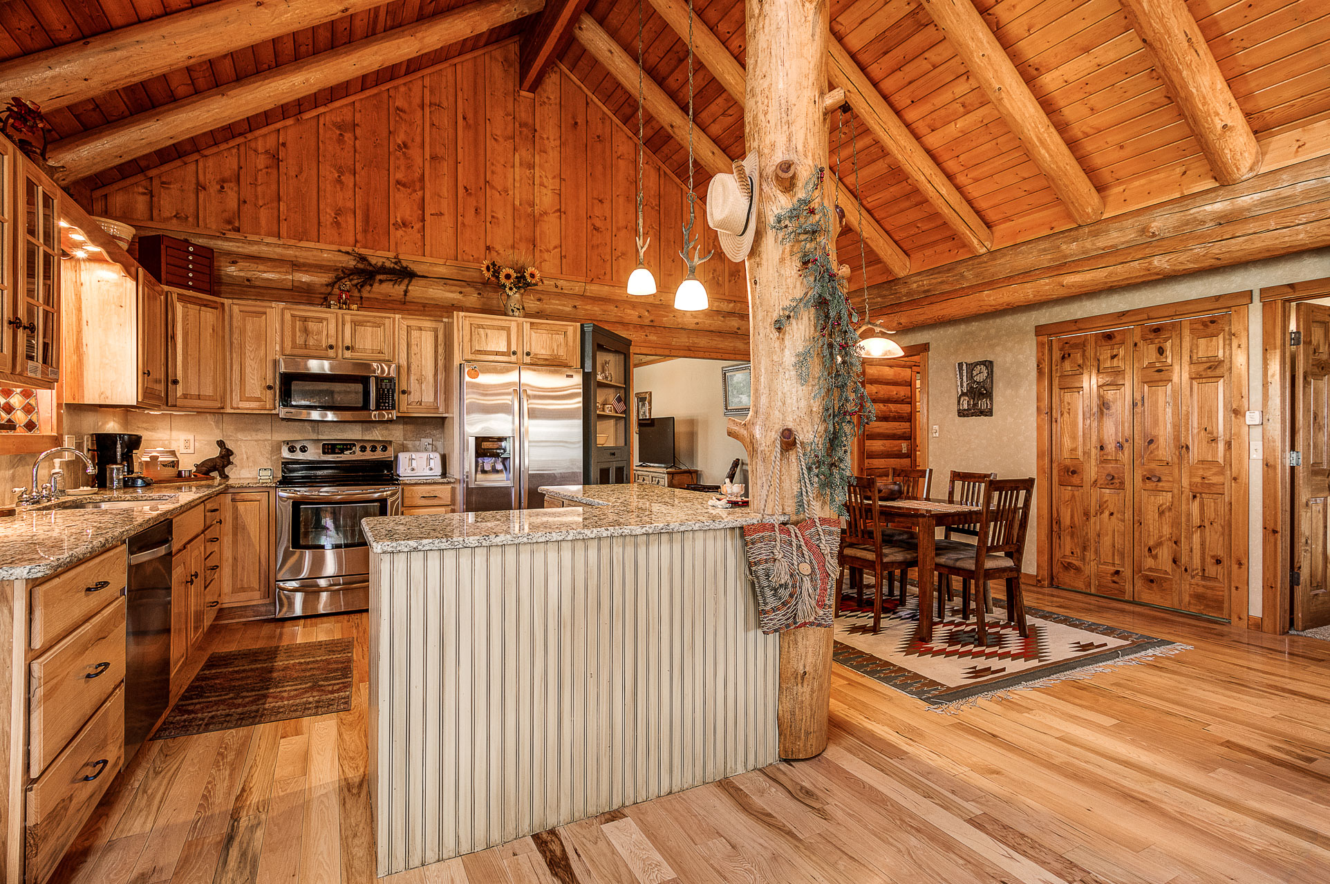 Cabin kitchen with log walls, granite counters, and a center island