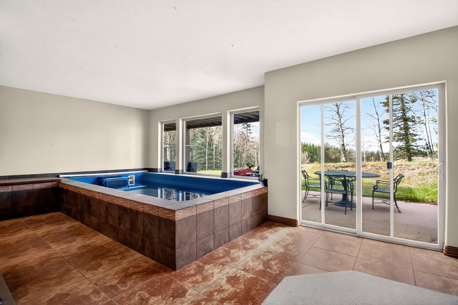 Indoor lap pool with windows to the trees