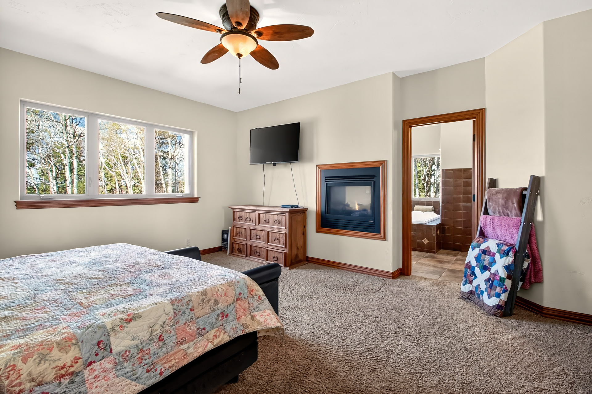 Primary bedroom with a fireplace and mountain window