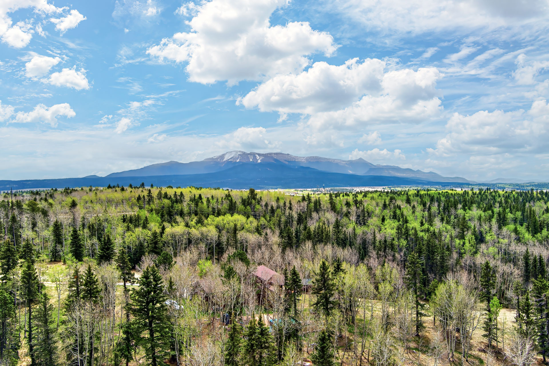 Aerial of the land with the high peaks on the horizon